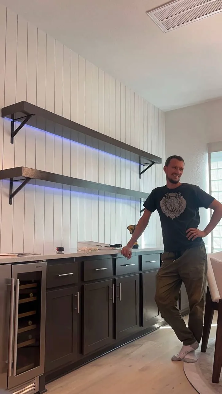 Shiplap accent wall with floating LED shelves bar area